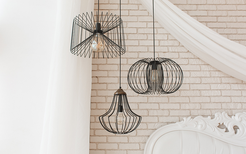Wire black design ceiling luster hanging in bedroom. Loft interior details Wire black design ceiling luster hanging in bedroom. Loft interior details.
